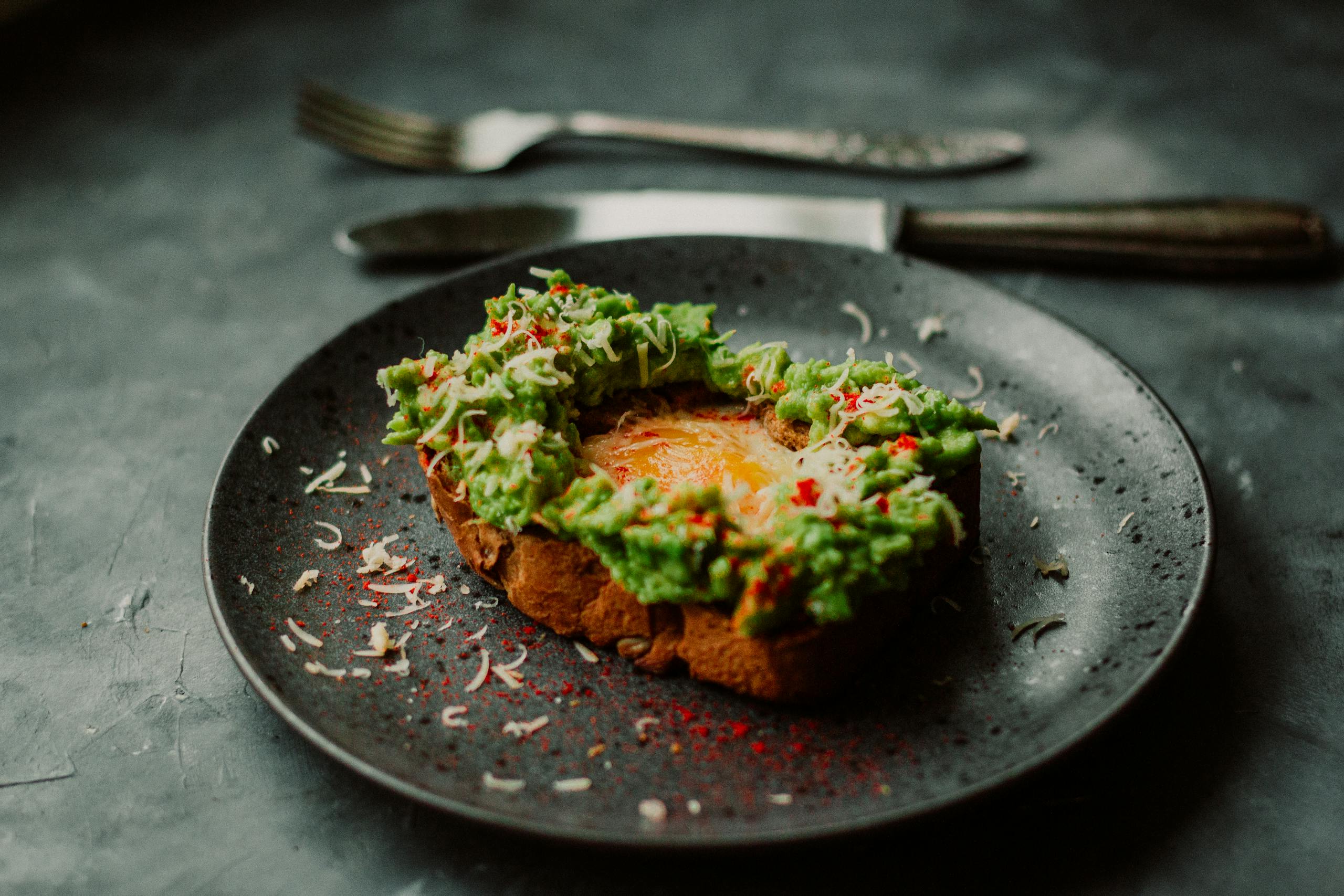 Delicious avocado toast with a poached egg, garnished with spices, perfect for breakfast or brunch.